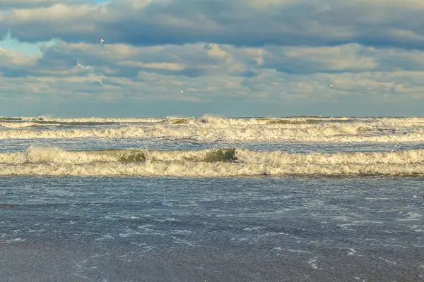 Kumlu bir sahilde dalgalar. Sahildeki deniz dalgaları.