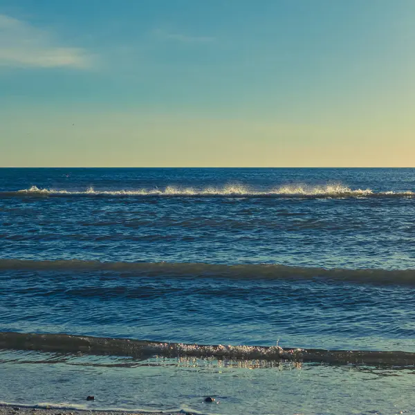 Deniz kıyısı, kumlu sahili olan güzel deniz manzarası, denizin ufku ve sakin bir su.
