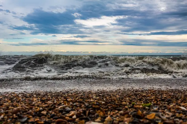 Deniz dalgaları yazın sahilde kayalara çarpıyor.