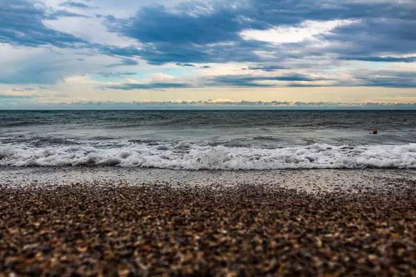 Akşamları güneşli bir günde sahilde dalgalar ve taşlar.