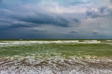 Kumsalda dalgalı fırtınalı bir deniz.