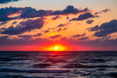 Denizin üzerinde gün batımı.