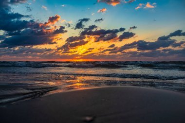 Sahilde dramatik bir gün batımı.