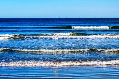 Deniz dalgaları ve mavi gökyüzü.