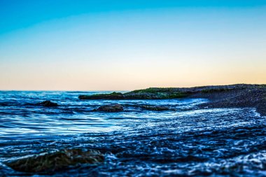 Akşamları deniz dalgaları ve mavi gökyüzü