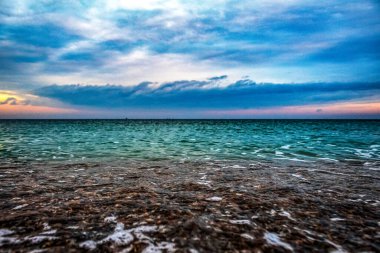 Akşamları sahilde gün batımı ve deniz.
