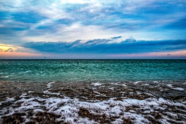 Deniz sahilinde gün batımı, bulutlu gökyüzü ile güzel bir gün batımı..