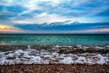 Deniz dalgaları ve köpükler denizin kıyısında