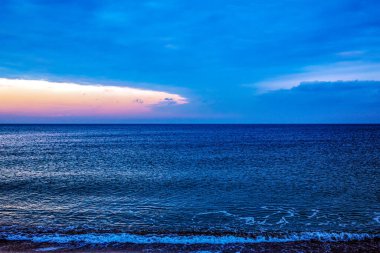 Dalgalı güzel deniz manzarası, gün batımı ve gökyüzü.