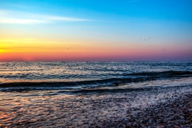 Deniz kıyısında günbatımı.