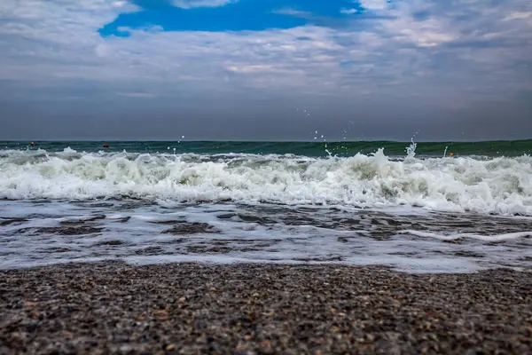 Deniz kumsalı, dalgalar ve bulutlar.