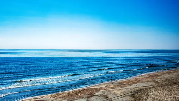 Baltık okyanusu kıyısı, mavi gökyüzü, mavi ve beyaz dalgaları olan güzel bir sahil. Yaz, güzel manzaralı cennet gibi bir deniz manzarası. Doğa, turizm