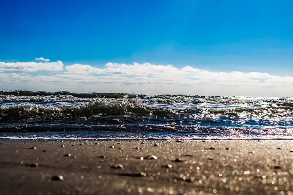 Mavi gökyüzünde deniz dalgaları.