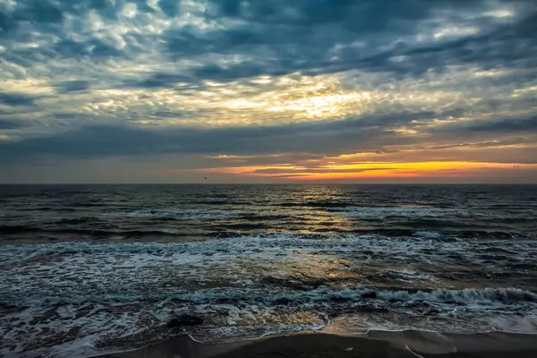 Denizin üzerinde dramatik gün batımı, renkli bulutlar, güzel gökyüzü ve bulutlar