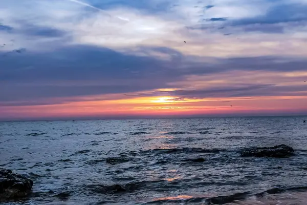 Günbatımı denize renkli bulutlar ile