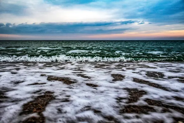 Deniz kıyısındaki dalgalar. Deniz köpükle kaplıdır..