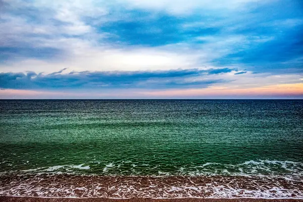 Deniz kıyısı ve günbatımı gökyüzü