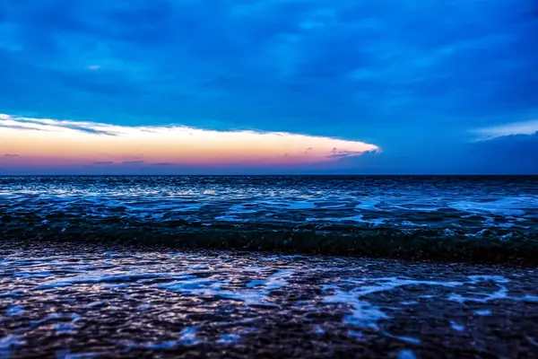 Sahilde gün batımı olan güzel bir deniz manzarası