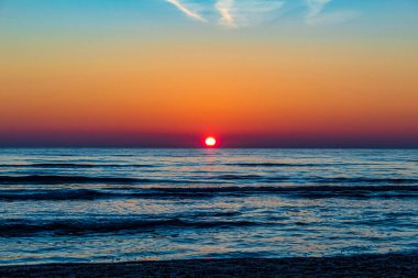 Dalgalarla denizde güzel bir gün batımı