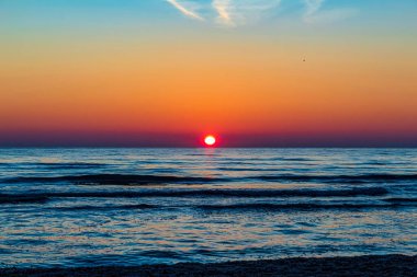 Güzel bir gökyüzü ve güzel bir plajı olan deniz kenarında gün doğumu.