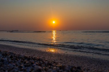 Sahilde gün batımı. Denizde güzel bir gün batımı.
