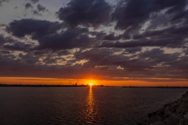 Denizde güzel bir gün doğumu, deniz fenerinin manzarası.