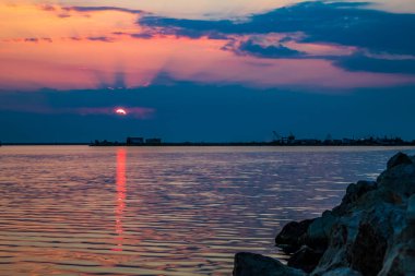 Güzel bir gökyüzü ve bulutlarla denizin üzerinde gün batımı