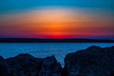 Deniz ve bulutların üzerinde renkli gün batımı