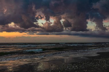 Denizde dramatik bulutlar. Denizin üzerinde gün batımı