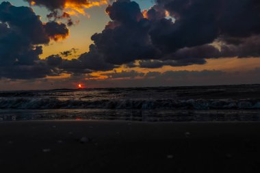 Kara plajda gün batımı