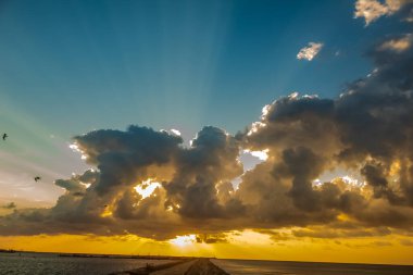 Güneş ve bulutlarla okyanusun üzerinde gün batımı