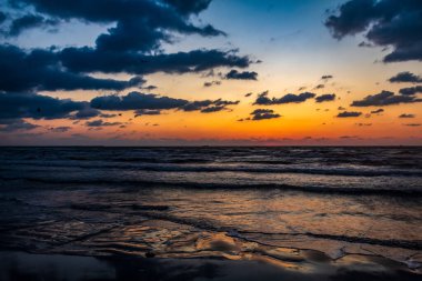 Denizin üzerinde güzel bir gün batımı. Bulutlu doğa arkaplanı.