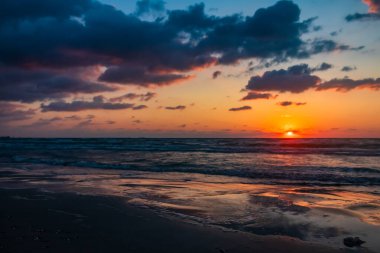 Sahilde gün batımı. Deniz kenarında gün batımı. Denizde güzel bir gün doğumu. Sahili olan güzel deniz manzarası.