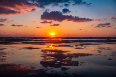 Sahilde gün batımı Renkli gökyüzü ve bulutlarla