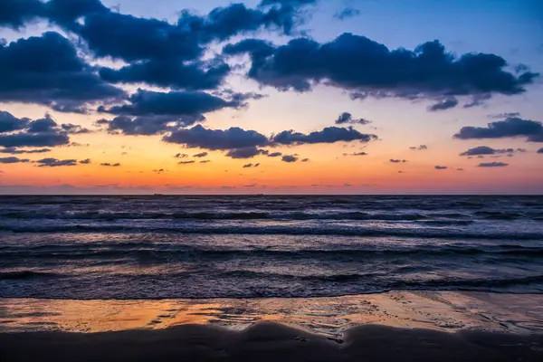 Deniz kıyısında renkli günbatımı.