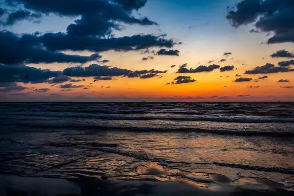 Denizin üzerinde güzel bir gün batımı. Bulutlu doğa arkaplanı.