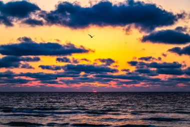 Denizde gün batımı, yaz akşamı gökyüzünde renkli bulutlar.