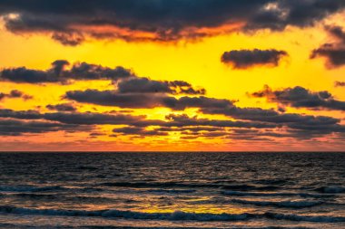 Bulutlu bir yaz gününde denizde güzel bir gün doğumu