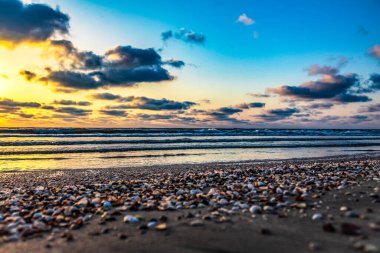 Sahilde büyük dalgalarla denizin üzerinde güzel bir gün doğumu..