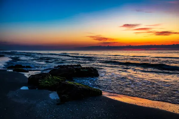 Sahilde gün doğumu Güzel renkli gökyüzü