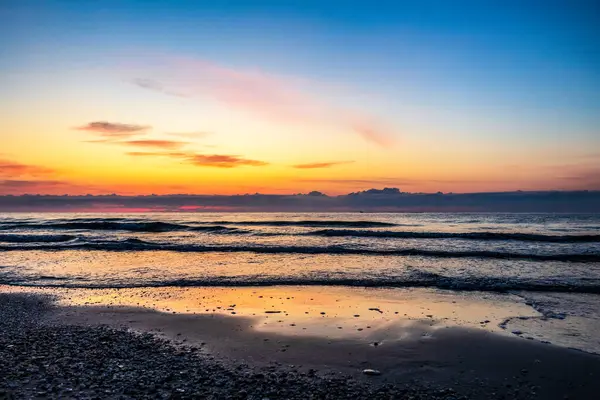 Büyük bir dalgayla denizin üzerinde güzel bir gün doğumu.