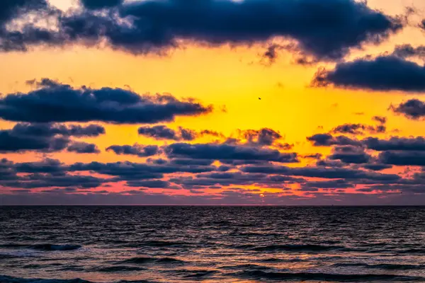 Denizin üzerinde renkli gün batımı, bulutlu güzel gün batımı gökyüzü