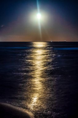 Güzel bir gün batımı, sakin bir deniz ve arkasında dolunay..