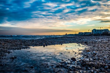 Küçük bir kasabanın kumlu sahilinde güzel bir gün batımı.