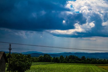 Dağları ve bulutlu gökyüzü olan güzel bir manzara.