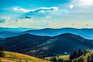 Dağları ve mavi gökyüzü olan güzel bir manzara.