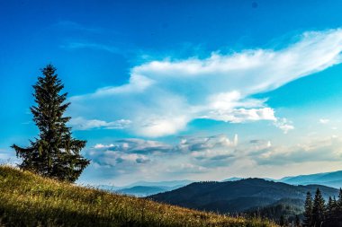 Bulutlu ve gökyüzü olan dağ manzarası