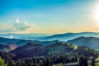Önünde bulutlar olan dağ manzarasının üzerinde güzel bir gün batımı..