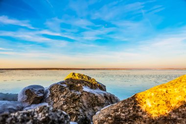 Donmuş gölün üzerinde gün batımı. Doğa manzarası.