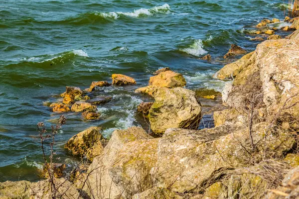 Deniz kıyısında, sahilde taşlar ve dalgalar.